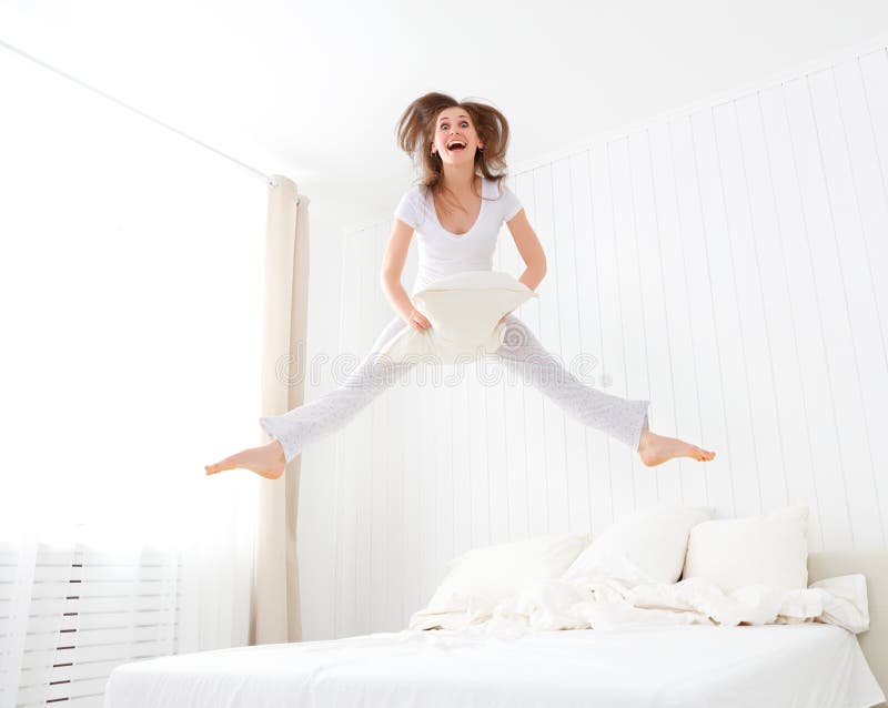 Gelukkig meisje die en pret in bed springen hebben stock afbeeldingen Gelukkig meisje die en pret in bed springen hebben stock afbeeldingen