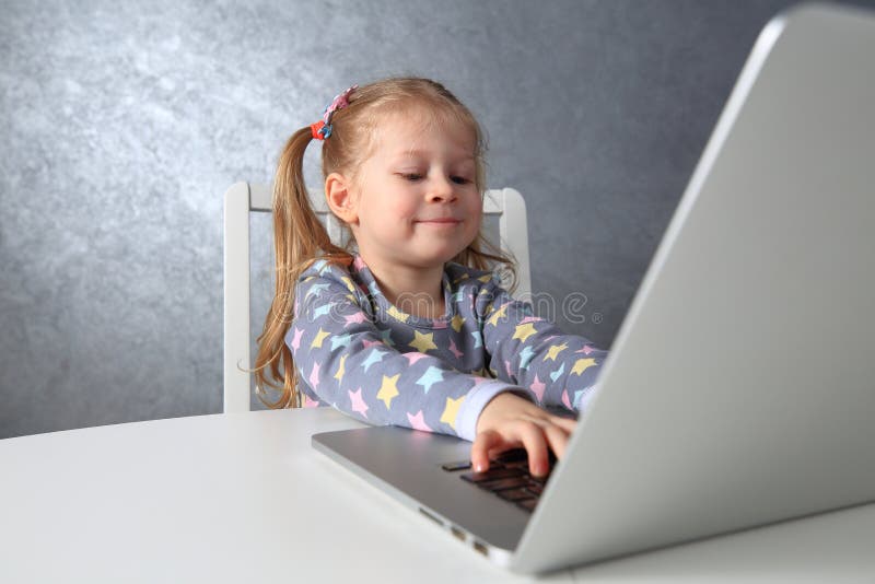 Gelukkig meisje die het computerwerk bestuderen Kind met witte laptop stock foto's Gelukkig meisje die het computerwerk bestuderen Kind met witte laptop stock foto's