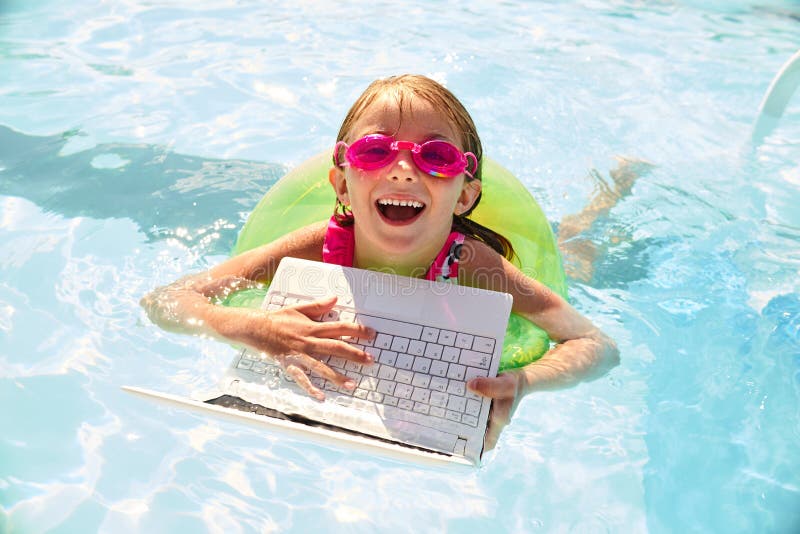 Gelukkig meisje die in pool met ring en laptop zwemmen stock fotografie Gelukkig meisje die in pool met ring en laptop zwemmen stock fotografie