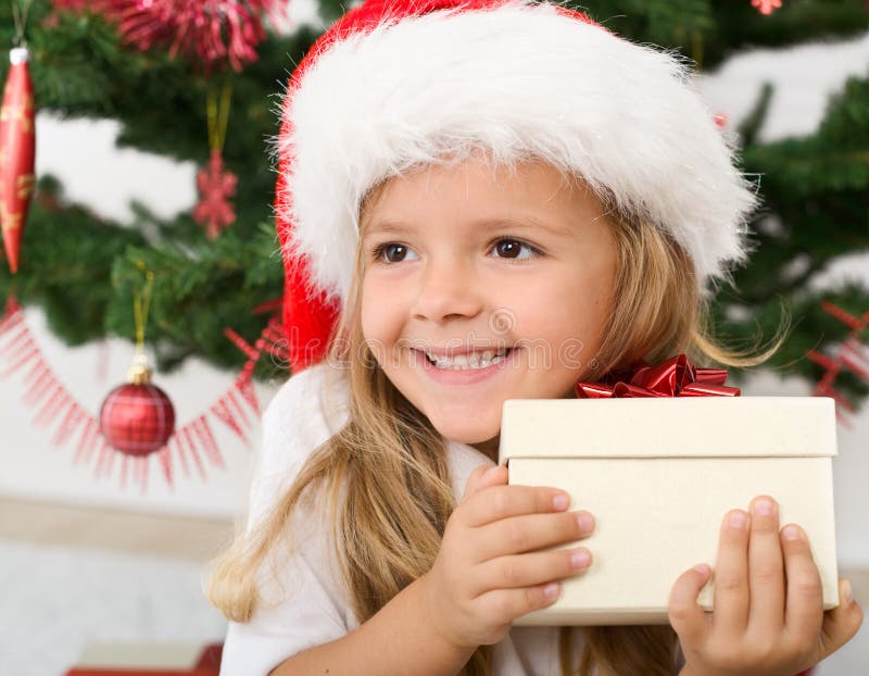 Happy little girl with christmas present smiling. Happy little girl with christmas present smiling