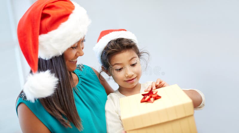 Gelukkig moeder en kind in santahoeden met giftdoos stock afbeeldingen Gelukkig moeder en kind in santahoeden met giftdoos stock afbeeldingen