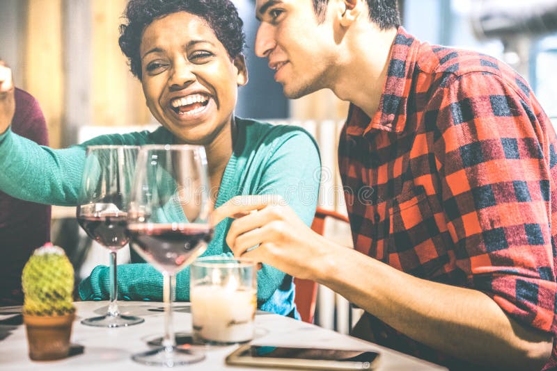 Gelukkig multiraciaal paar van minnaars die rode wijn drinken bij de wijnmakerij van de manierbar royalty-vrije stock afbeelding Gelukkig multiraciaal paar van minnaars die rode wijn drinken bij de wijnmakerij van de manierbar royalty-vrije stock afbeelding