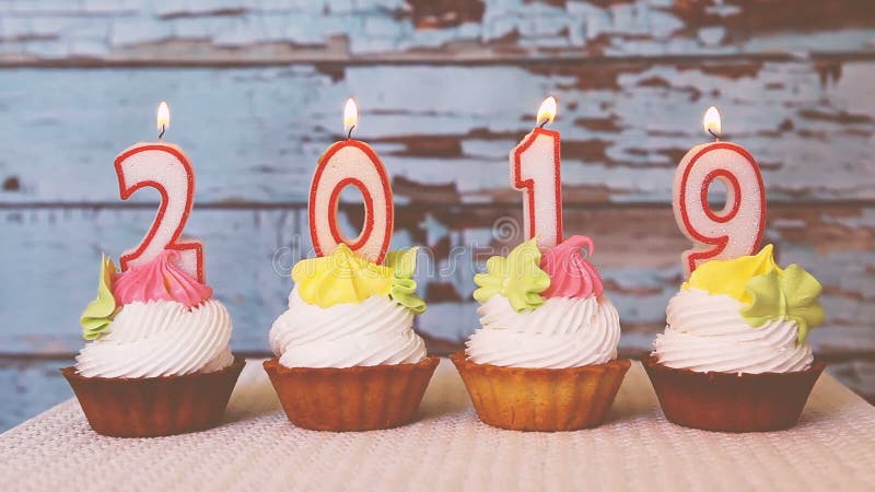 Gelukkig nieuw jaar 2019, aantalkaarsen op cupcakes met uitstekende achtergrond