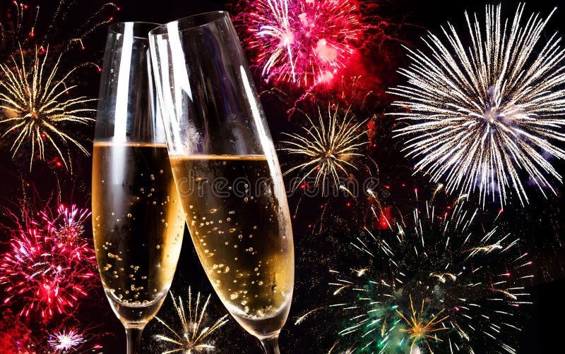 Two flutes of champagne over fireworks display. Two flutes of champagne over fireworks display