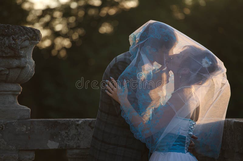 Gelukkig paar die en elkaar koesteren kussen onder sluier op backgr royalty-vrije stock fotografie Gelukkig paar die en elkaar koesteren kussen onder sluier op backgr royalty-vrije stock fotografie