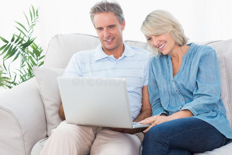 Gelukkig paar die laptop samen op de laag met behulp van royalty-vrije stock foto Gelukkig paar die laptop samen op de laag met behulp van royalty-vrije stock foto