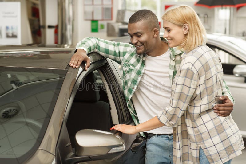 Gelukkig paar die nieuwe auto kopen samen bij het handel drijven stock fotografie Gelukkig paar die nieuwe auto kopen samen bij het handel drijven stock fotografie