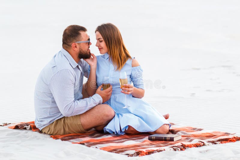 Gelukkig paar die van picknick op het witte zandstrand en wijn drinken of champagne genieten tijdens romantisch diner, het jonge royalty-vrije stock foto's Gelukkig paar die van picknick op het witte zandstrand en wijn drinken of champagne genieten tijdens romantisch diner, het jonge royalty-vrije stock foto's