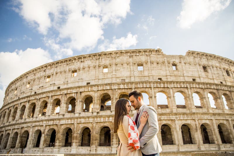 Gelukkig paar die voor Colosseum in Rome, Italië koesteren royalty-vrije stock afbeelding Gelukkig paar die voor Colosseum in Rome, Italië koesteren royalty-vrije stock afbeelding