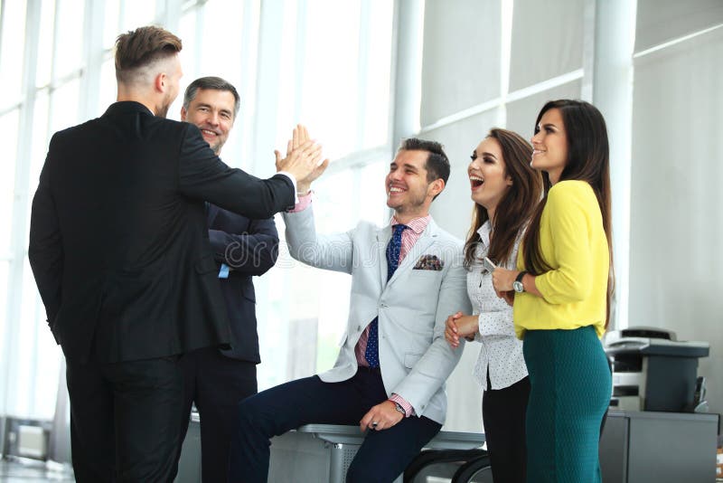 Gelukkig succesvol multiraciaal commercieel team die een hoog fivesgebaar geven aangezien zij lachen en hun succes toejuichen royalty-vrije stock foto Gelukkig succesvol multiraciaal commercieel team die een hoog fivesgebaar geven aangezien zij lachen en hun succes toejuichen royalty-vrije stock foto