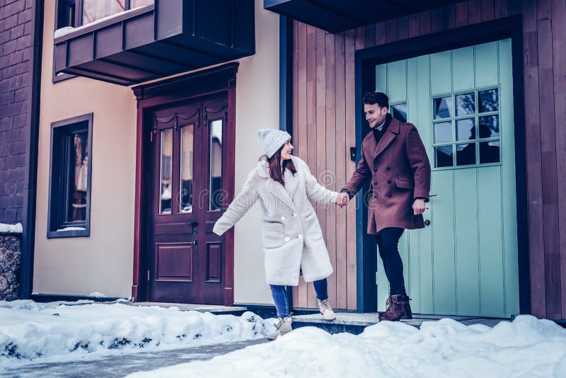 Gelukkig vrolijk paar die uit van huis voor gang in de winter lopen stock foto's Gelukkig vrolijk paar die uit van huis voor gang in de winter lopen stock foto's