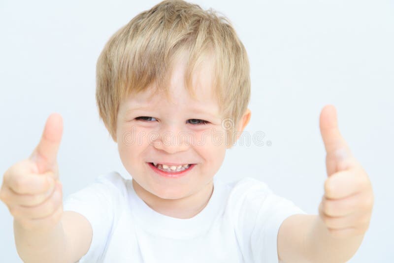 Gelukkig weinig jongen met duimen omhoog op wit stock foto Gelukkig weinig jongen met duimen omhoog op wit stock foto