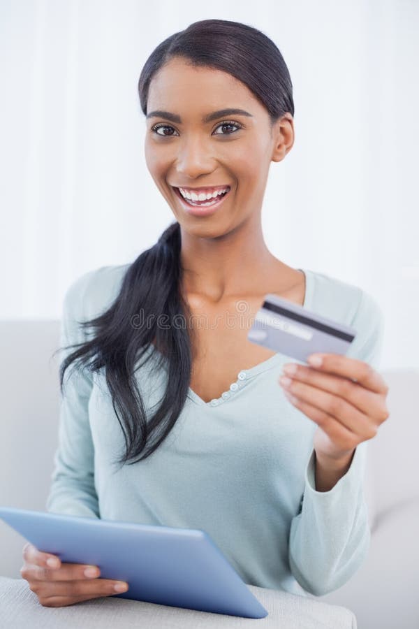 Gelukkige aantrekkelijke vrouw die haar tabletpc met behulp van online te kopen royalty-vrije stock foto Gelukkige aantrekkelijke vrouw die haar tabletpc met behulp van online te kopen royalty-vrije stock foto