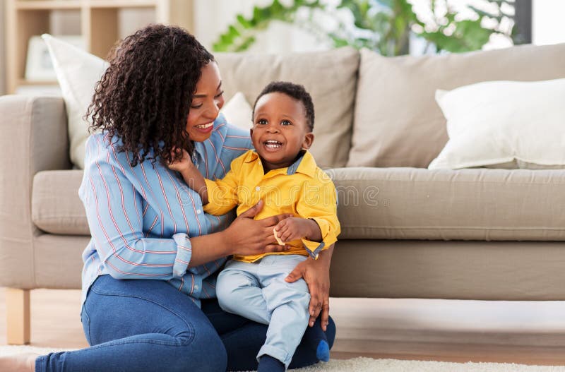 Gelukkige Afrikaanse Amerikaanse moeder met baby thuis stock foto's Gelukkige Afrikaanse Amerikaanse moeder met baby thuis stock foto's