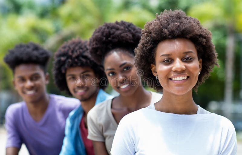 Gelukkige Afrikaanse Amerikaanse vrouw met groep jonge volwassenen in lijn