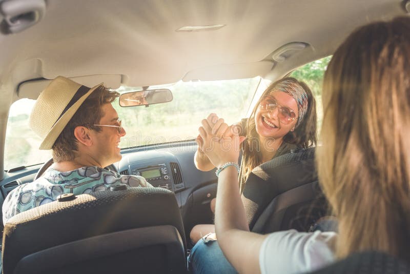 Gelukkige in auto zitten en vrienden die samen reizen stock afbeeldingen Gelukkige in auto zitten en vrienden die samen reizen stock afbeeldingen