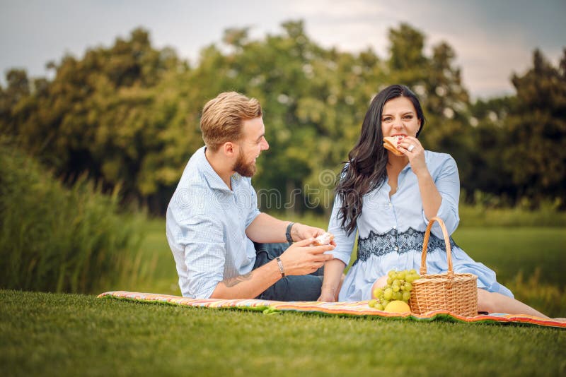 Gelukkige blije jonge familieechtgenoot en zijn zwangere vrouw die pret hebben samen in openlucht, bij picknick in de zomerpark stock afbeeldingen Gelukkige blije jonge familieechtgenoot en zijn zwangere vrouw die pret hebben samen in openlucht, bij picknick in de zomerpark stock afbeeldingen