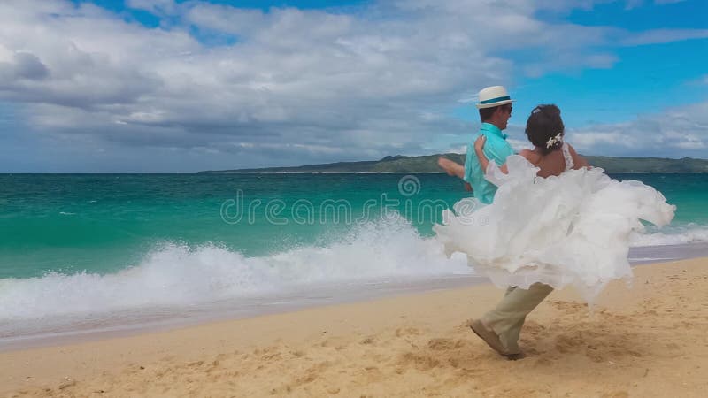 Gelukkige bruid en bruidegom die pret op een tropisch strand hebben Enkel marri