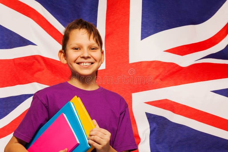 Gelukkige Engelse student met handboeken onder zijn wapen royalty-vrije stock afbeelding Gelukkige Engelse student met handboeken onder zijn wapen royalty-vrije stock afbeelding