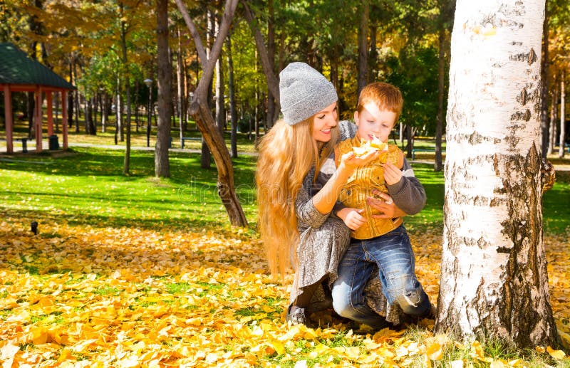 Gelukkige familie: de moeder en het kind sonr hebben pret in de herfst op de herfstpark Jong Moeder en jong geitjemeisje die in b royalty-vrije stock afbeeldingen Gelukkige familie: de moeder en het kind sonr hebben pret in de herfst op de herfstpark Jong Moeder en jong geitjemeisje die in b royalty-vrije stock afbeeldingen