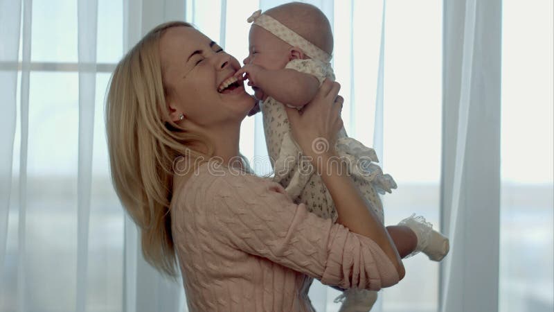 Gelukkige Familie De moeder werpt omhoog en kussende baby royalty-vrije stock afbeelding Gelukkige Familie De moeder werpt omhoog en kussende baby royalty-vrije stock afbeelding