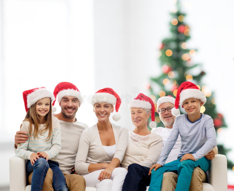 Gelukkige familie die in de hoeden van de santahelper op laag zitten stock foto's Gelukkige familie die in de hoeden van de santahelper op laag zitten stock foto's