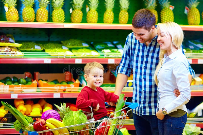 Gelukkige familie die gezond voedsel in supermarkt kopen stock afbeelding Gelukkige familie die gezond voedsel in supermarkt kopen stock afbeelding