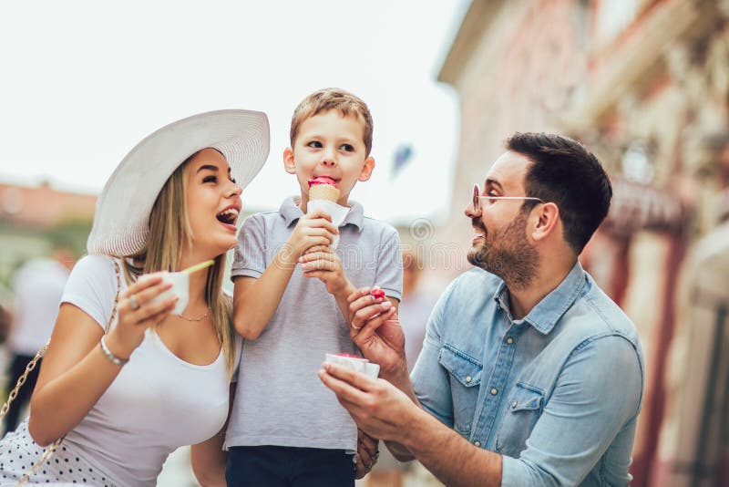 Gelukkige familie die hun weekend met zoon doorbrengen Zij eten het roomijs stock fotografie Gelukkige familie die hun weekend met zoon doorbrengen Zij eten het roomijs stock fotografie