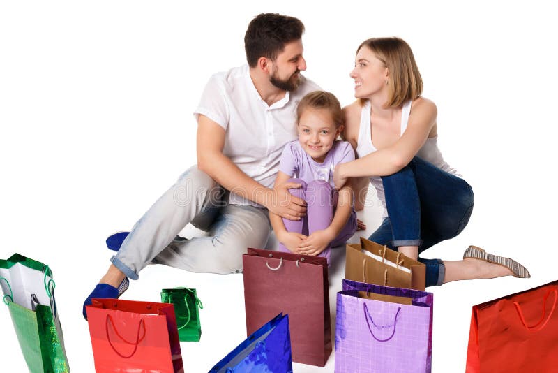 Gelukkige familie die met het winkelen zakken bij studio zitten stock fotografie Gelukkige familie die met het winkelen zakken bij studio zitten stock fotografie