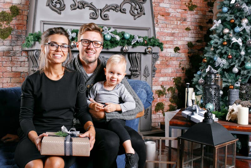 Gelukkige familie die pret heeft thuis In zolderruimte met bakstenen muur Jonge ouders met weinig zoon Vader, moeder en hun stock fotografie Gelukkige familie die pret heeft thuis In zolderruimte met bakstenen muur Jonge ouders met weinig zoon Vader, moeder en hun stock fotografie
