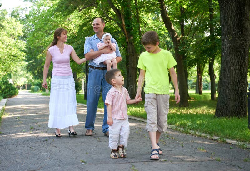 Gelukkige familie die in stadspark, groep van vijf mensen, zomer, kind en ouder lopen stock afbeeldingen Gelukkige familie die in stadspark, groep van vijf mensen, zomer, kind en ouder lopen stock afbeeldingen