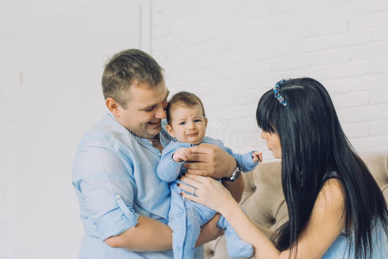 Gelukkige familie die uit mamma en papa` s babyjongen bestaan De gelukkige verhoudingen van de Familie royalty-vrije stock fotografie Gelukkige familie die uit mamma en papa` s babyjongen bestaan De gelukkige verhoudingen van de Familie royalty-vrije stock fotografie