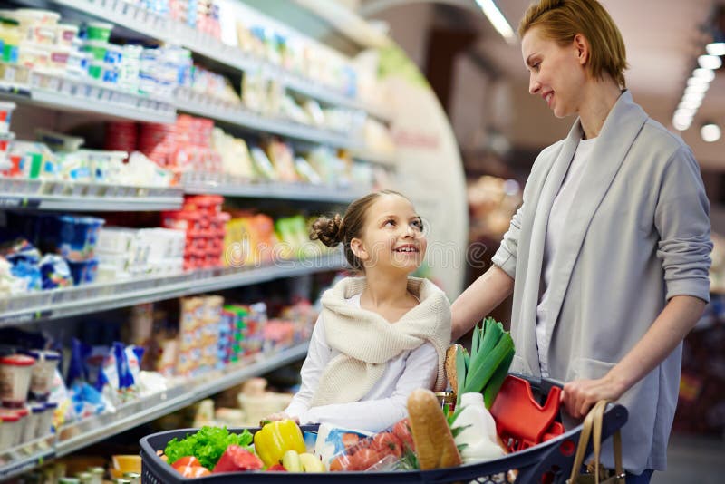 Gelukkige Familie met Volledig Boodschappenwagentje in Supermarkt stock fotografie Gelukkige Familie met Volledig Boodschappenwagentje in Supermarkt stock fotografie