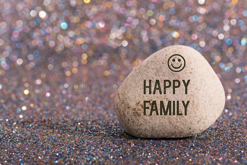 A white stone with words Happy family and smile face on color glitter boke background. A white stone with words Happy family and smile face on color glitter boke background