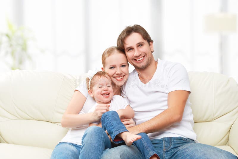 Happy family mother, father, child baby daughter at home on the sofa playing and laughing. Happy family mother, father, child baby daughter at home on the sofa playing and laughing