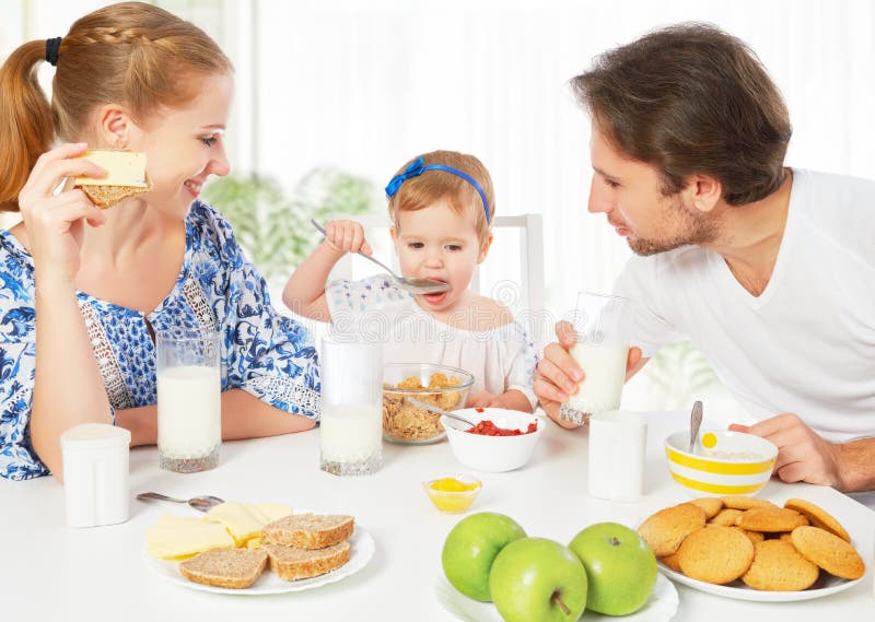 Happy family mother, father, child baby daughter having breakfast at home. Happy family mother, father, child baby daughter having breakfast at home