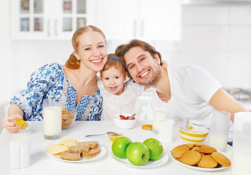 Happy family mother, father, child baby daughter having breakfast at home. Happy family mother, father, child baby daughter having breakfast at home