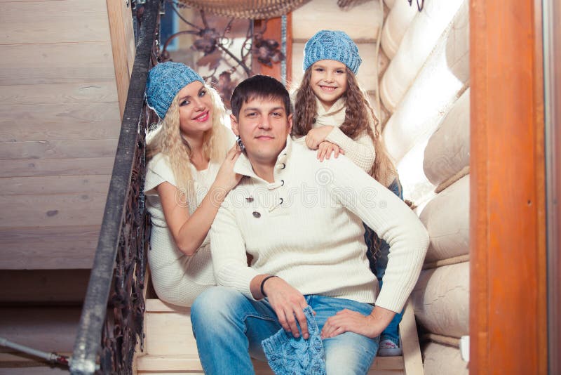Gelukkige familiemoeder, vader, kinddochter thuis, in een een de wintersweater en hoed, het concept Kerstmis op royalty-vrije stock afbeelding Gelukkige familiemoeder, vader, kinddochter thuis, in een een de wintersweater en hoed, het concept Kerstmis op royalty-vrije stock afbeelding