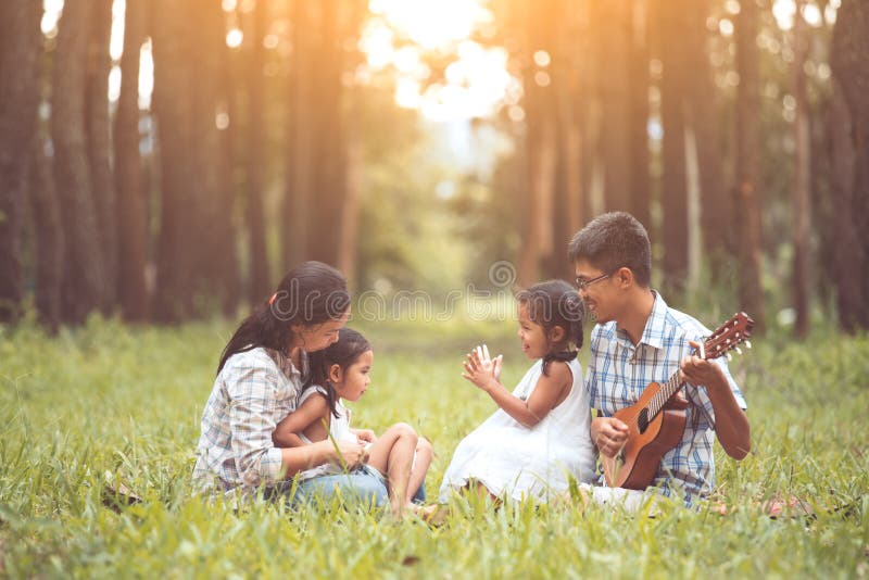 Gelukkige familievader het spelen gitaar met moeder en kind royalty-vrije stock foto Gelukkige familievader het spelen gitaar met moeder en kind royalty-vrije stock foto