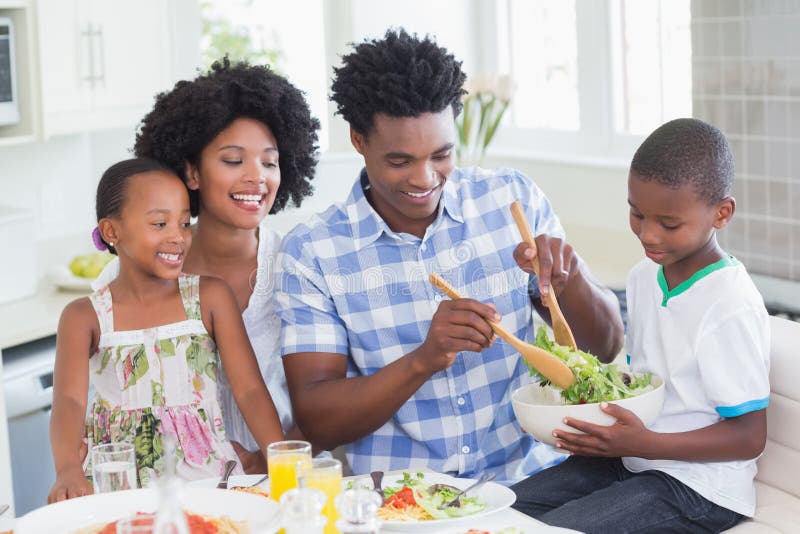 Gelukkige familiezitting neer aan diner samen stock fotografie Gelukkige familiezitting neer aan diner samen stock fotografie