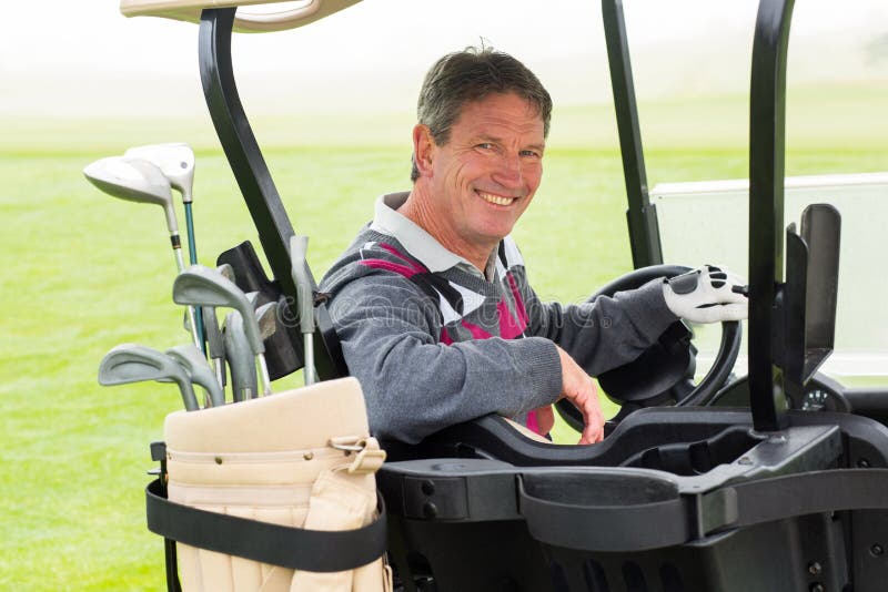 Gelukkige golfspeler die zijn golf glimlachen drijven het met fouten bij camera stock foto Gelukkige golfspeler die zijn golf glimlachen drijven het met fouten bij camera stock foto
