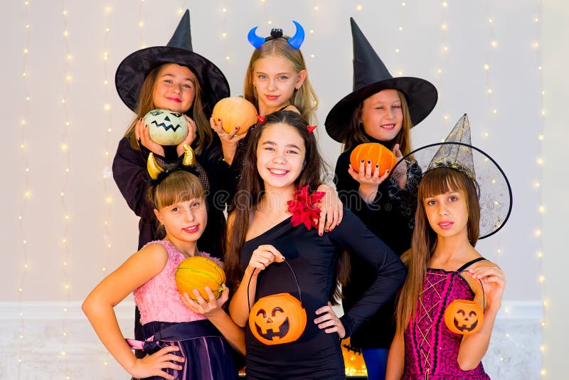Gelukkige groep tieners in Halloween-kostuums die op camera stellen stock foto Gelukkige groep tieners in Halloween-kostuums die op camera stellen stock foto
