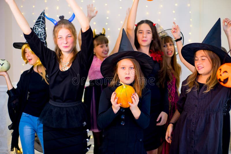 Gelukkige groep tienersdans in Halloween-kostuums stock afbeelding Gelukkige groep tienersdans in Halloween-kostuums stock afbeelding