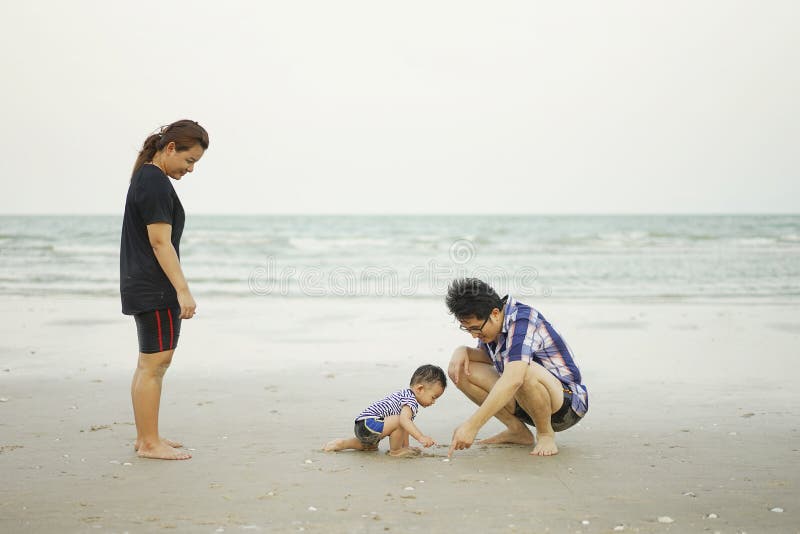 Gelukkige Jonge Aziatische Familie die Pret op tropische strandvakantie o hebben stock fotografie Gelukkige Jonge Aziatische Familie die Pret op tropische strandvakantie o hebben stock fotografie