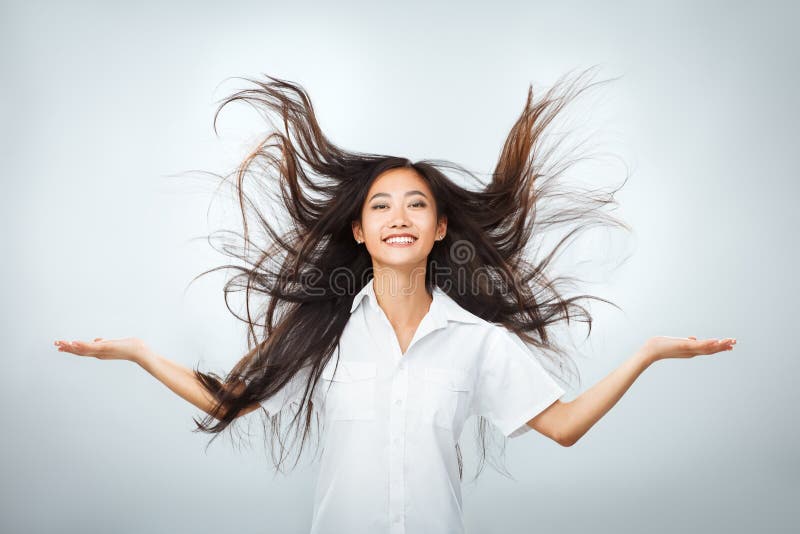 Gelukkige jonge Aziatische vrouw met mooi vliegend lang haar stock afbeeldingen Gelukkige jonge Aziatische vrouw met mooi vliegend lang haar stock afbeeldingen