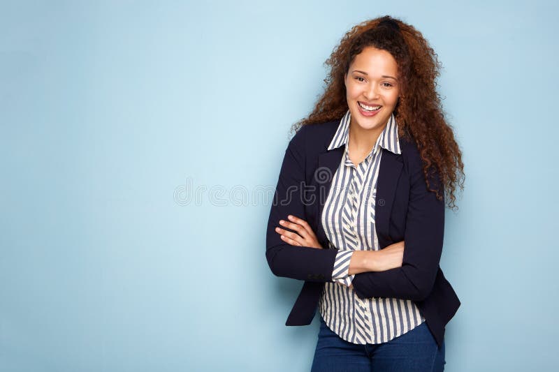 Gelukkige jonge bedrijfsvrouw die tegen blauwe achtergrond glimlachen stock fotografie Gelukkige jonge bedrijfsvrouw die tegen blauwe achtergrond glimlachen stock fotografie