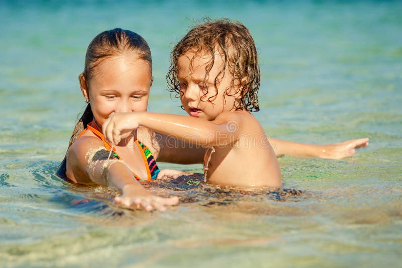 Gelukkige jonge geitjes die op strand spelen stock afbeeldingen Gelukkige jonge geitjes die op strand spelen stock afbeeldingen