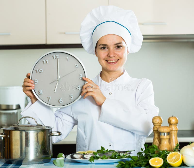 Gelukkige jonge kok die smakelijke vissen voor diner voorbereiden royalty-vrije stock foto's Gelukkige jonge kok die smakelijke vissen voor diner voorbereiden royalty-vrije stock foto's