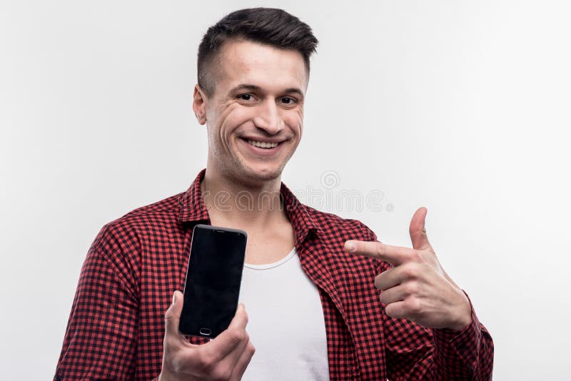 Gelukkige jonge mens die gelukkige holding voelen zijn nieuwe zwarte slimme telefoon stock afbeelding Gelukkige jonge mens die gelukkige holding voelen zijn nieuwe zwarte slimme telefoon stock afbeelding