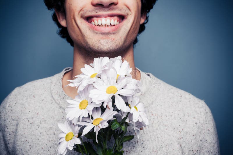 Gelukkige jonge mens met bloemen royalty-vrije stock fotografie Gelukkige jonge mens met bloemen royalty-vrije stock fotografie